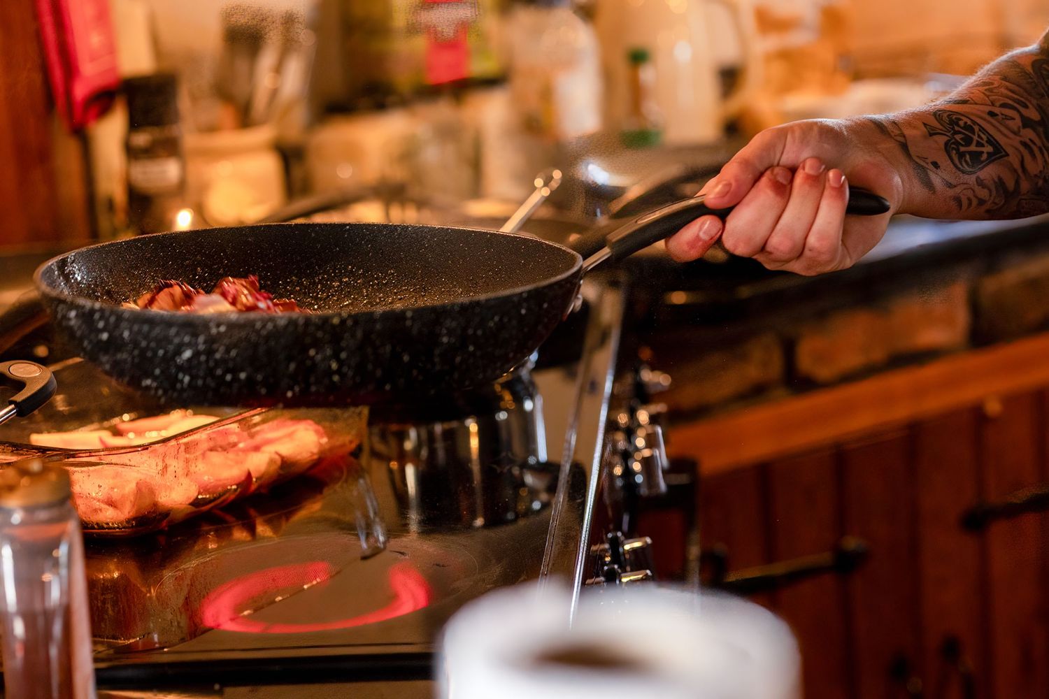 Close up of chef preparing food on the hob during an intimate wedding meal at Windmill Farm in Burscough.
