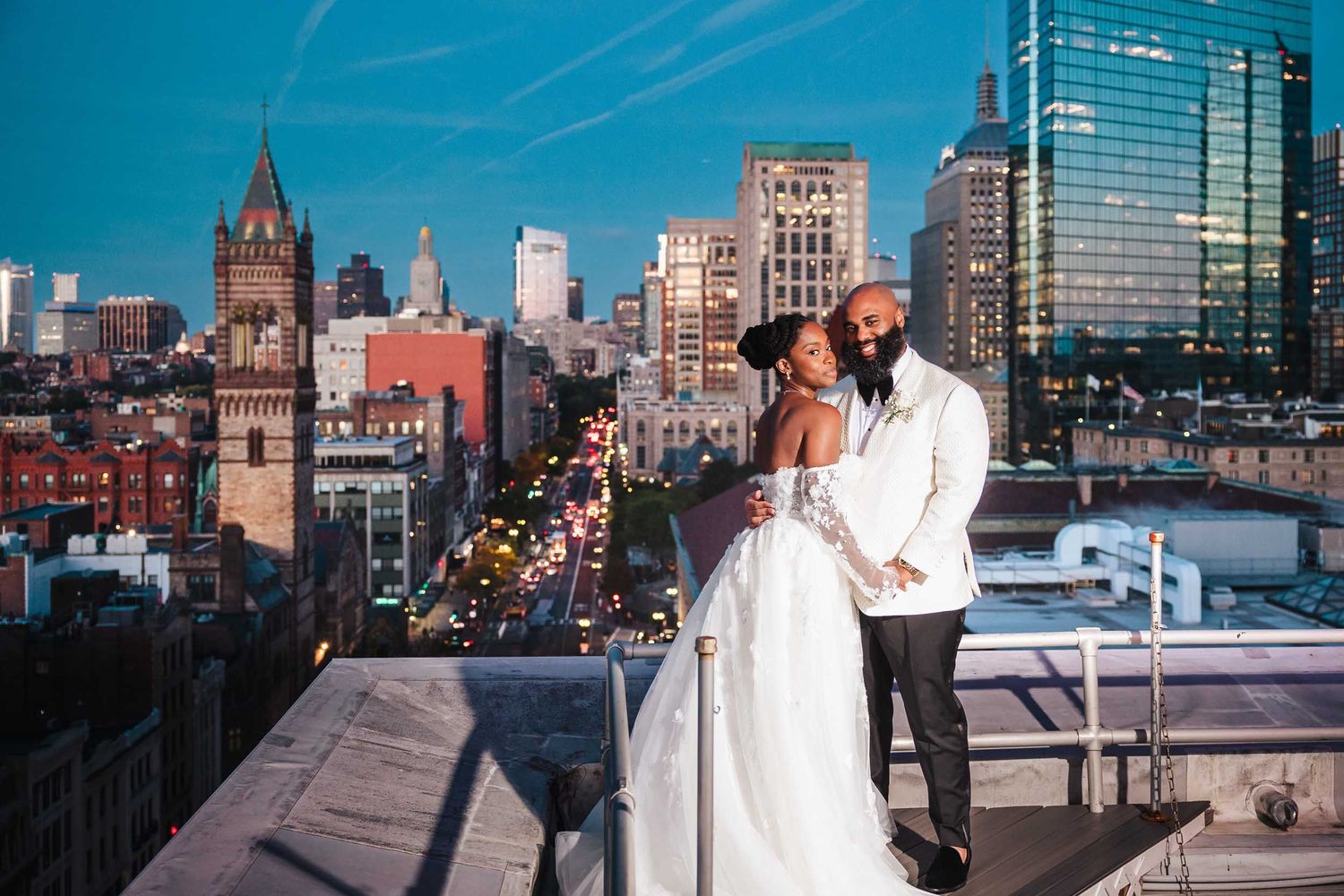 Romantic rooftop wedding portrait at Lenox Hotel Boston with Boston skyline glowing at dusk