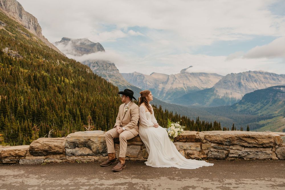 Glacier National Park Eloping Bride and Groom sitting along the Going to the sun road, by local Elopement Photographer Sabrina Marie