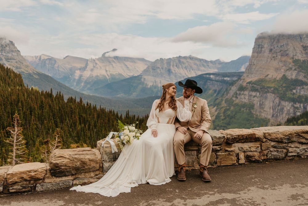 Glacier National Park Eloping Bride and Groom sitting along the Going to the sun road, by local Elopement Photographer Sabrina Marie