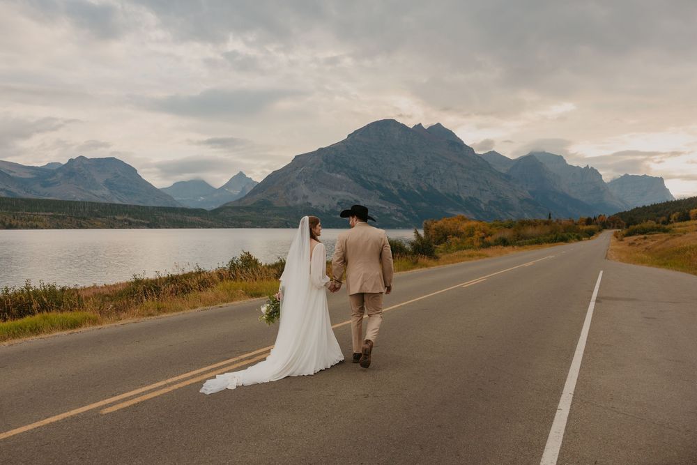 Glacier National Park Eloping Bride and Groom walking the Going to the sun road, by local Elopement Photographer Sabrina Marie