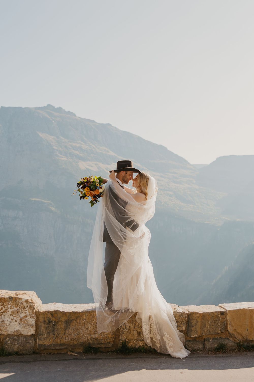 Glacier National Park Eloping Bride and Groom kissing on going to the Sun Road, captured by local Elopement Photographer Sabrina Marie