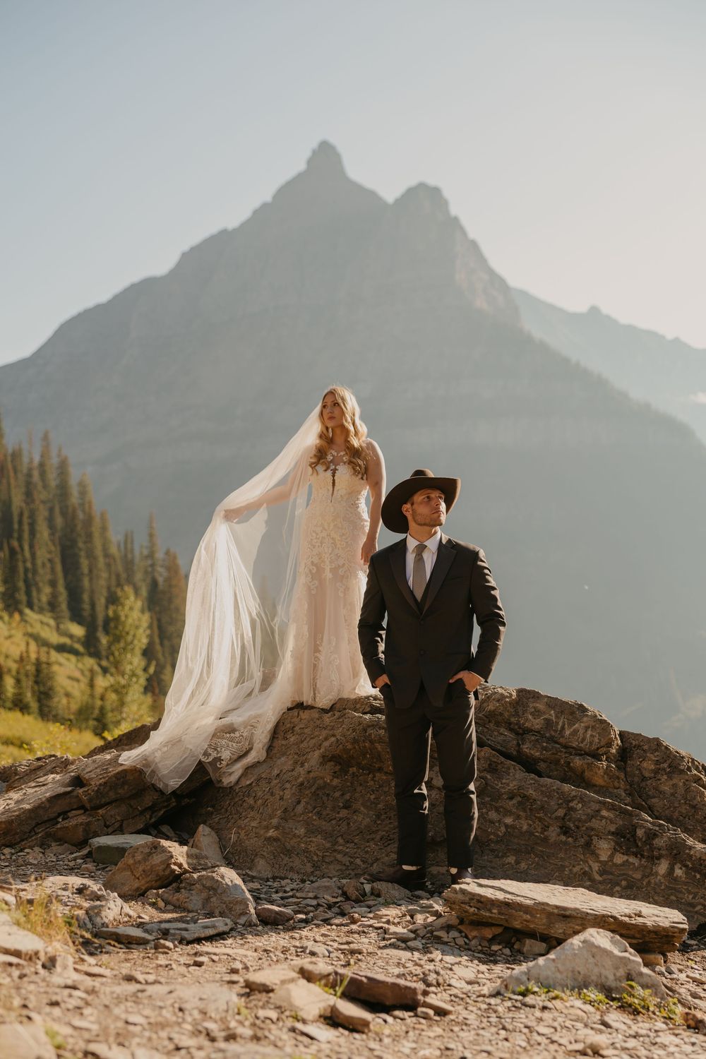 Glacier National Park Eloping Western Bride and Groom stand at Big bend taking in the mountain views in Glacier National Park