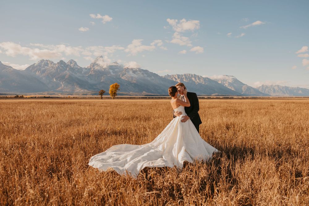 Bride and Groom dancing out into the Tetons under the fall sunset captured by a Grand Teton National Park Elopement Photographer
