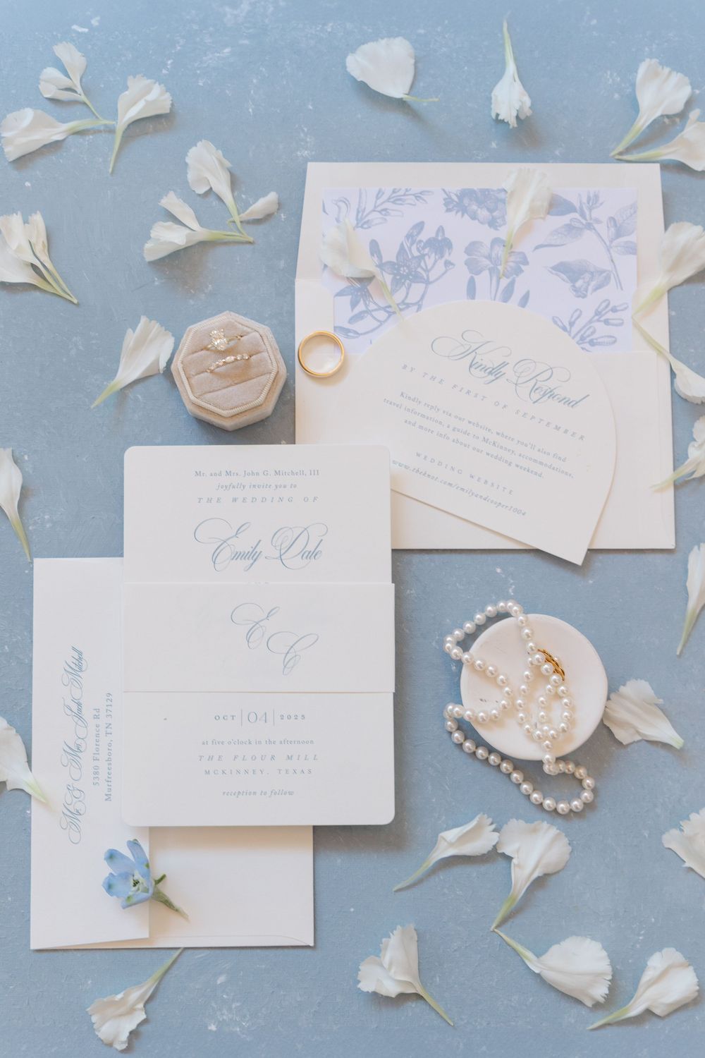 Classic blue and white wedding invitation suite with toile envelope liner, pearl jewelry, and floral accents.