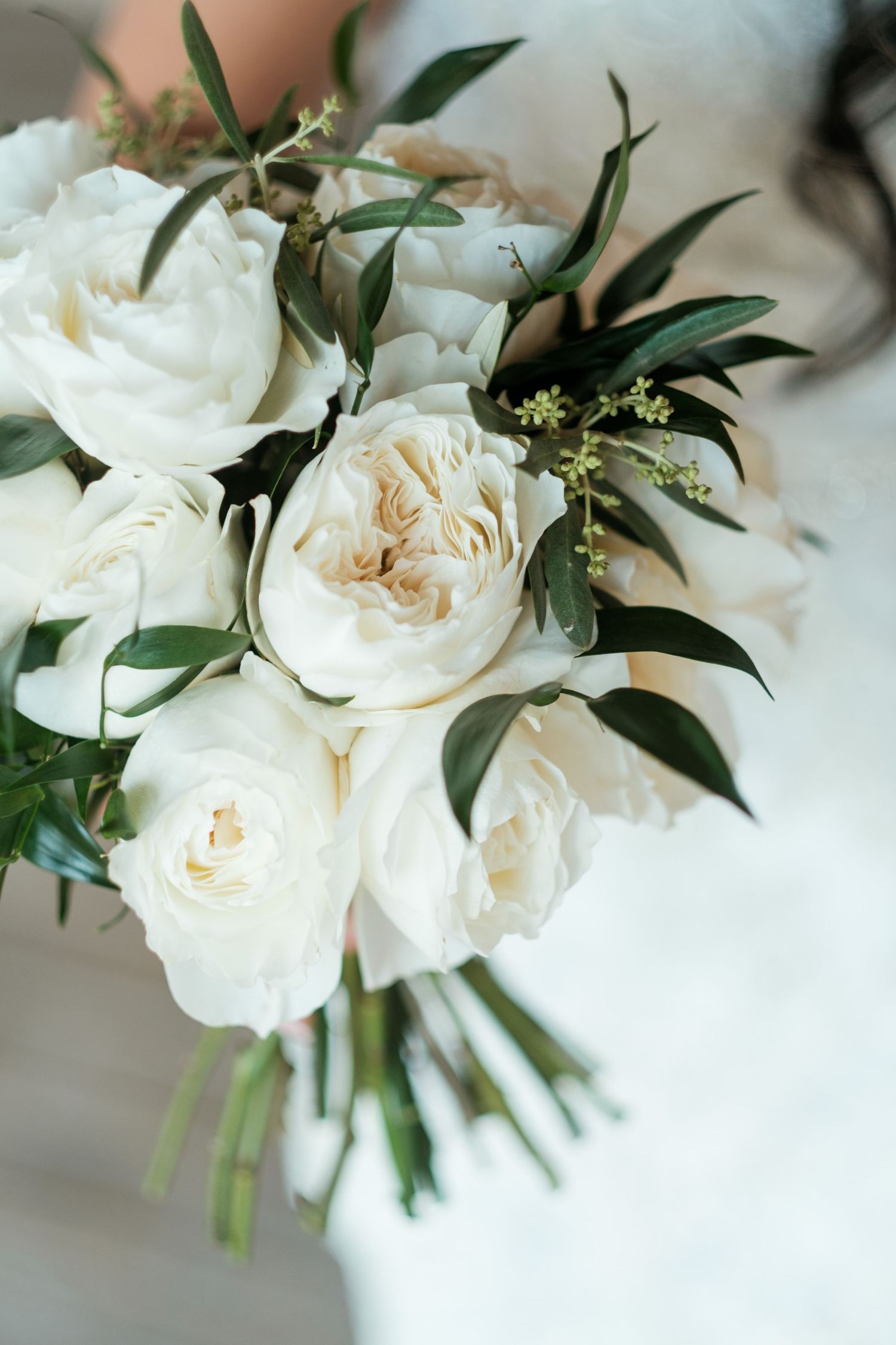 Elegant white rose bridal bouquet with green foliage and delicate garden roses.