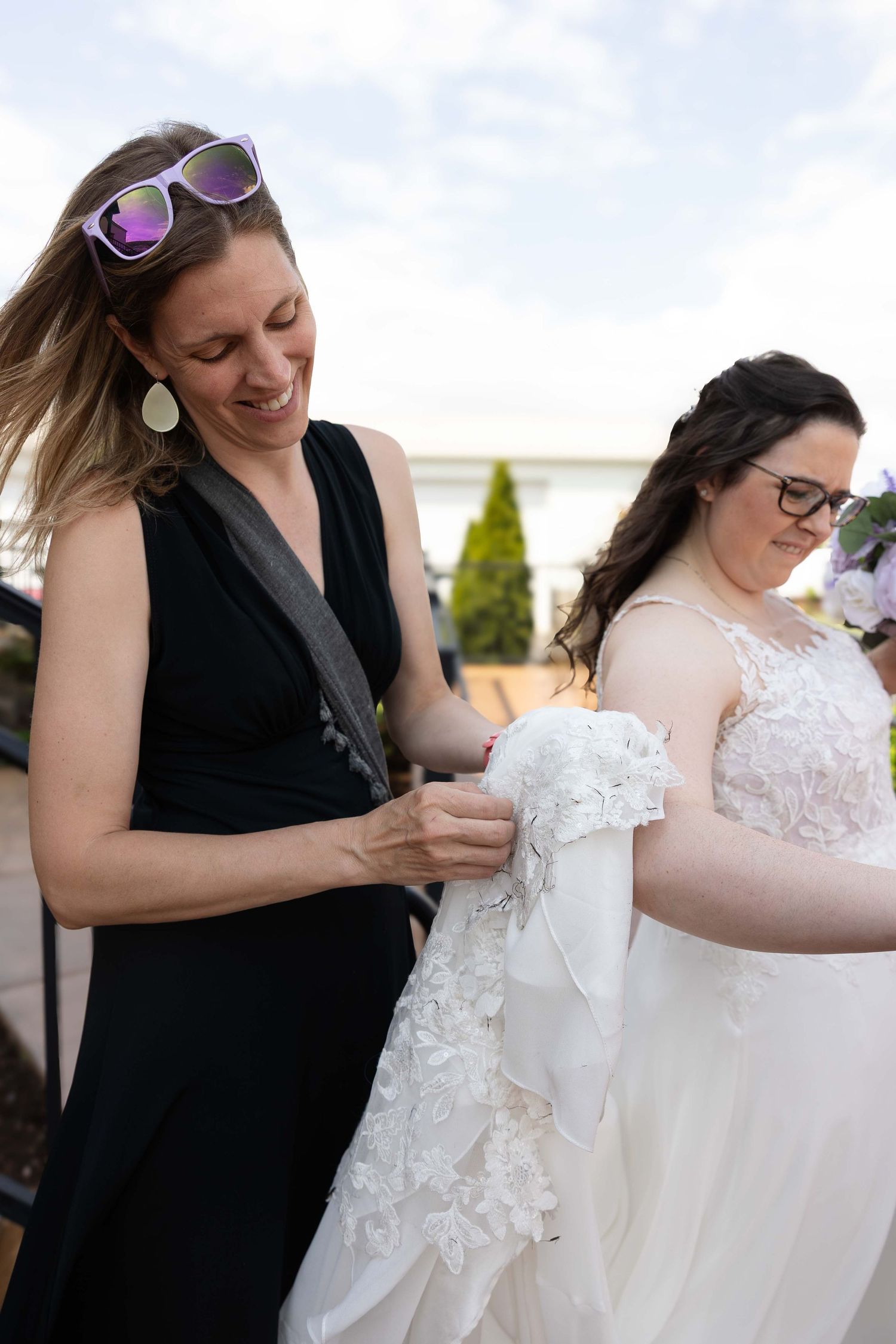 A wedding dress being carefully adjusted and fitted by someone wearing black in a series of detail shots.