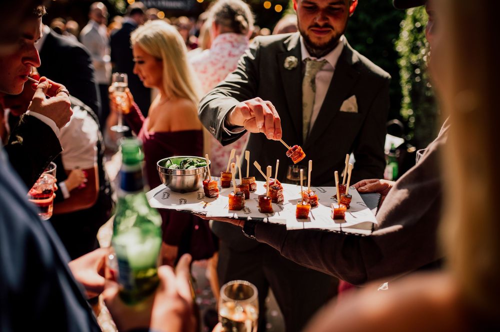 Wedding guests enjoy appetizers and drinks during an elegant cocktail hour reception.
