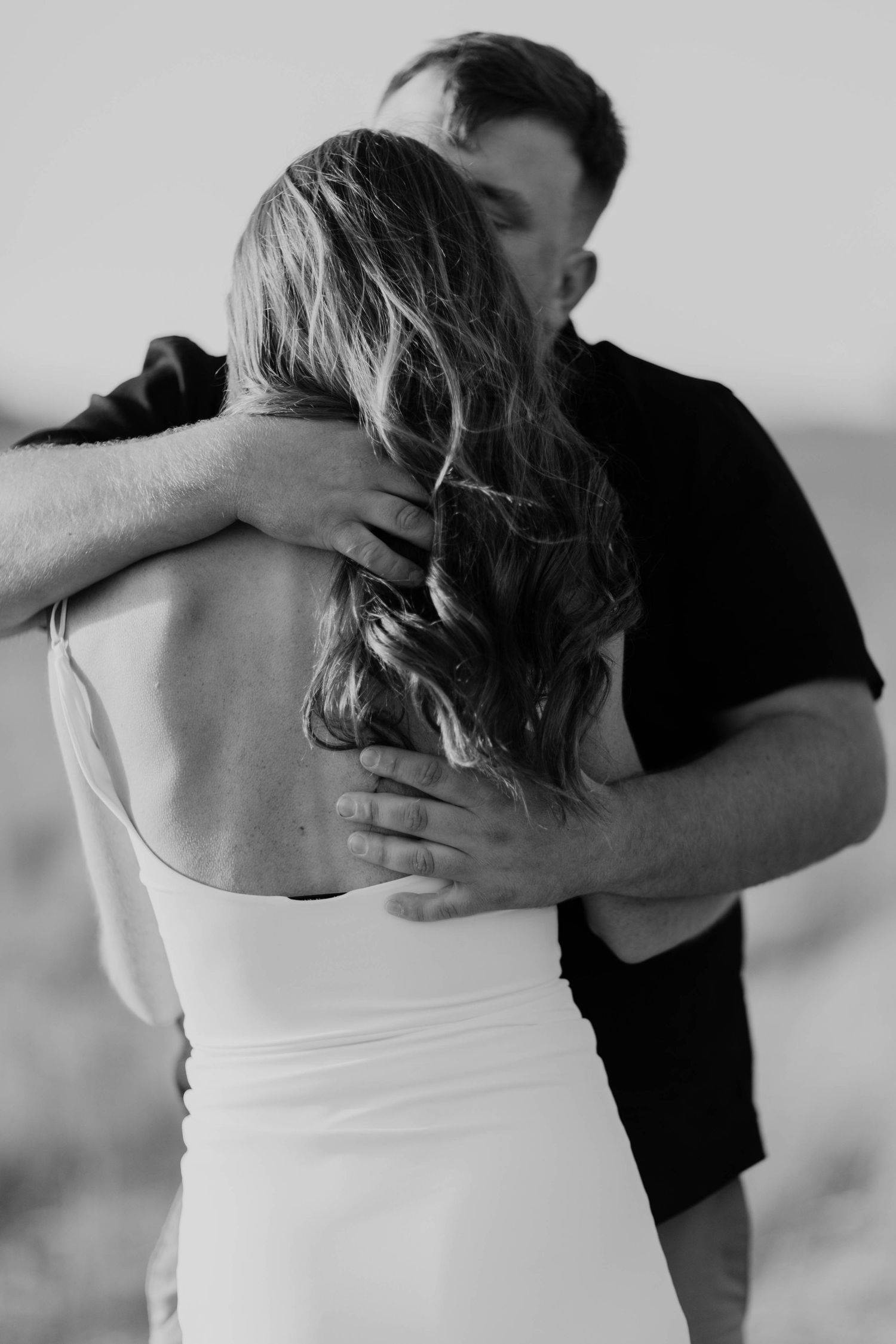 A series of black and white intimate photos showing two people embracing in different poses wearing black and white clothing.