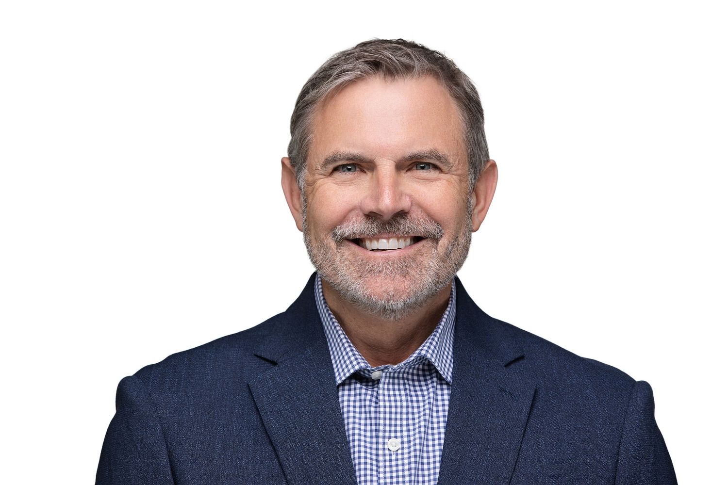 Professional headshot of someone in a navy suit and checkered dress shirt smiling warmly at the camera.