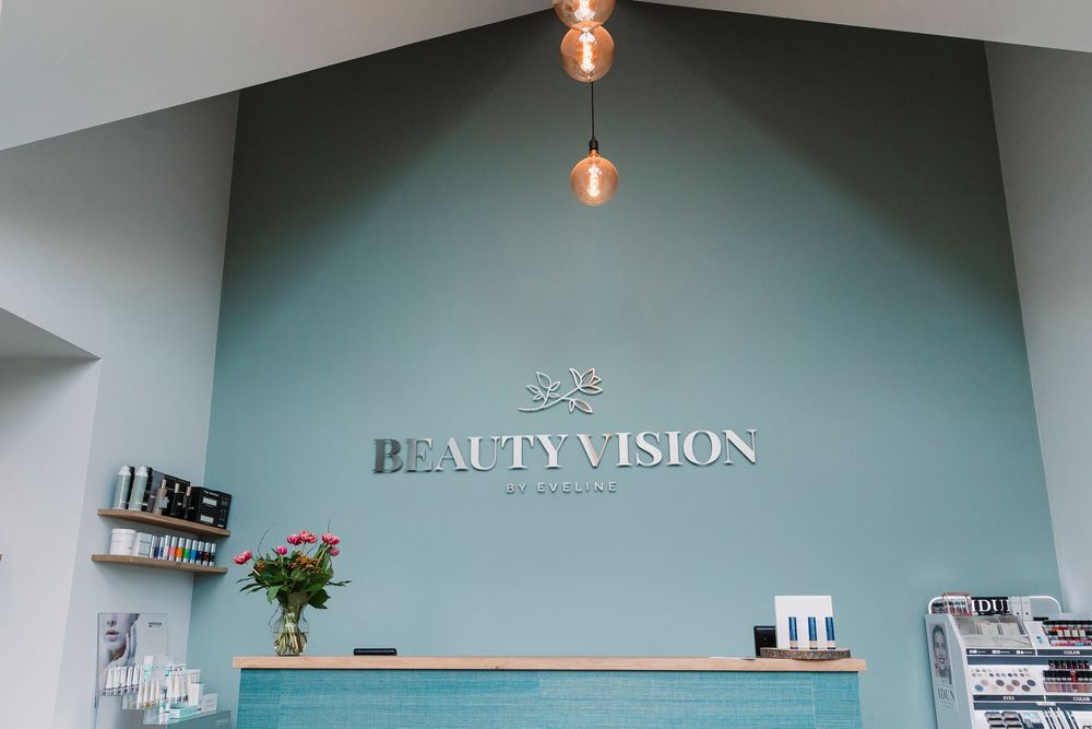 Modern beauty salon interior with Beauty Vision signage and pendant lighting.