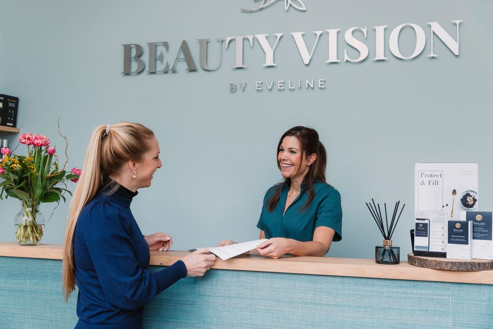 Beauty salon reception area with teal walls and modern decor.