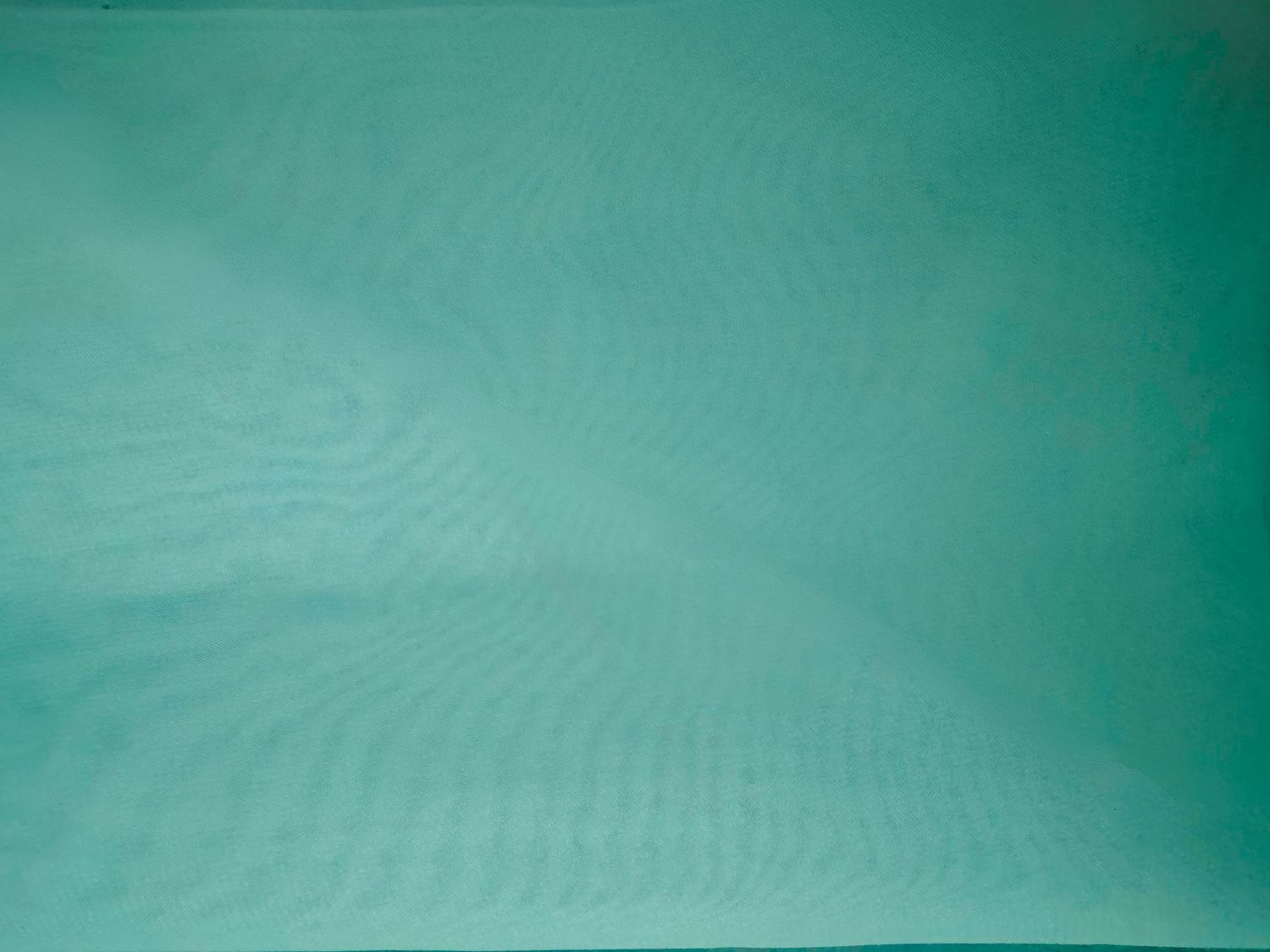 A sample colour of a green silk chiffon that can be worn for maternity portraits.