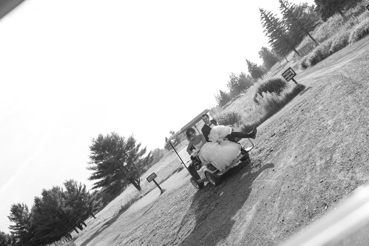 Candid Montreal Wedding Photography by Aliza Dworkind. Black and white photo of bride and groom laughing on a golf cart.