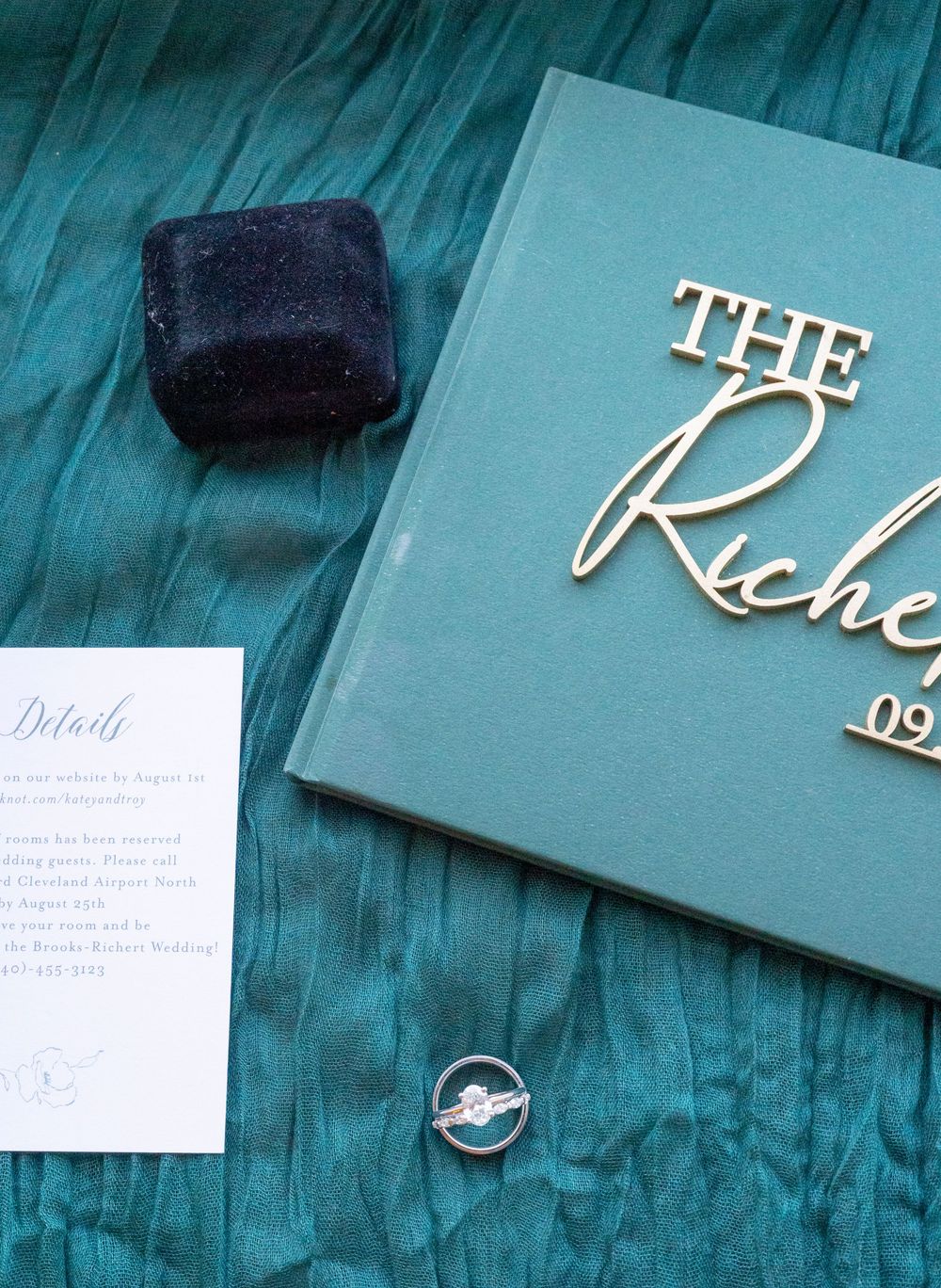 Elegant turquoise wedding invitation suite with white calligraphy lettering and matching envelopes arranged on dark surface.