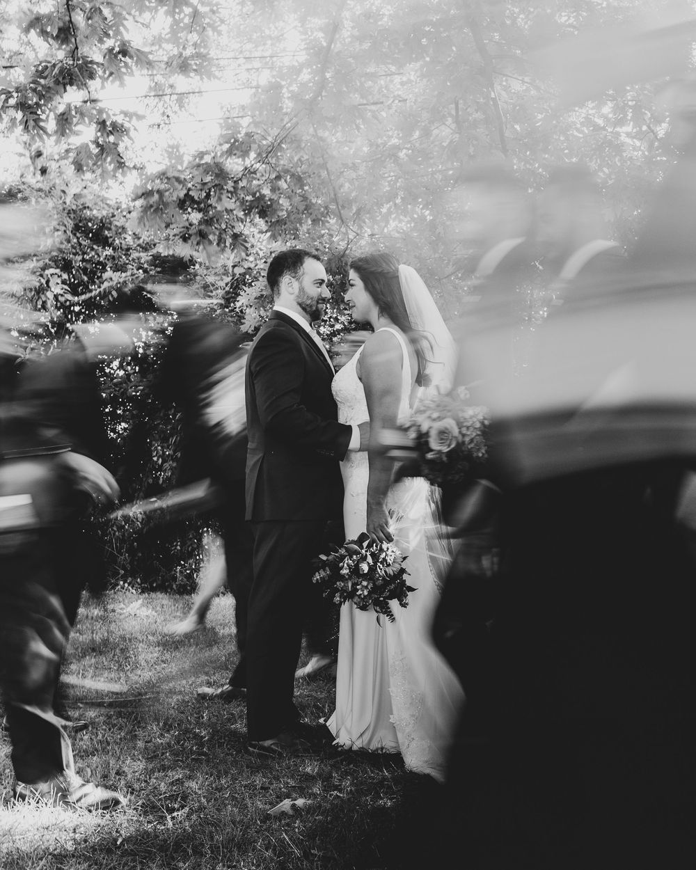 A series of black and white artistic wedding photos showing couples in an outdoor garden setting.