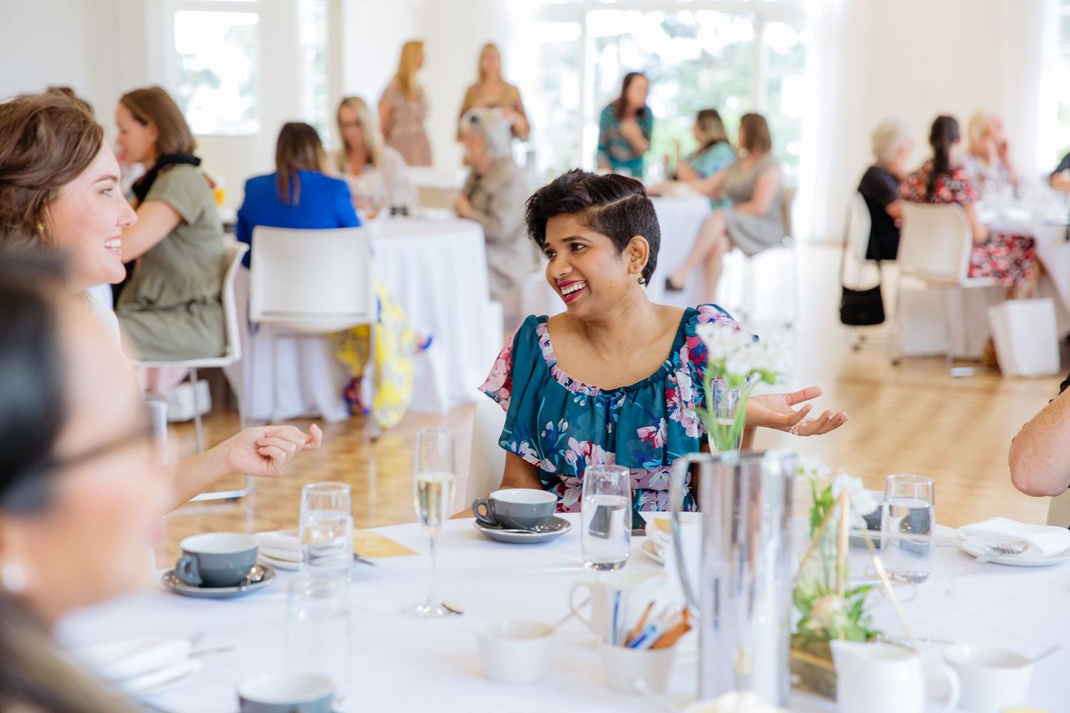 Fashion event photography in Auckland showing guests networking and enjoying an afternoon function