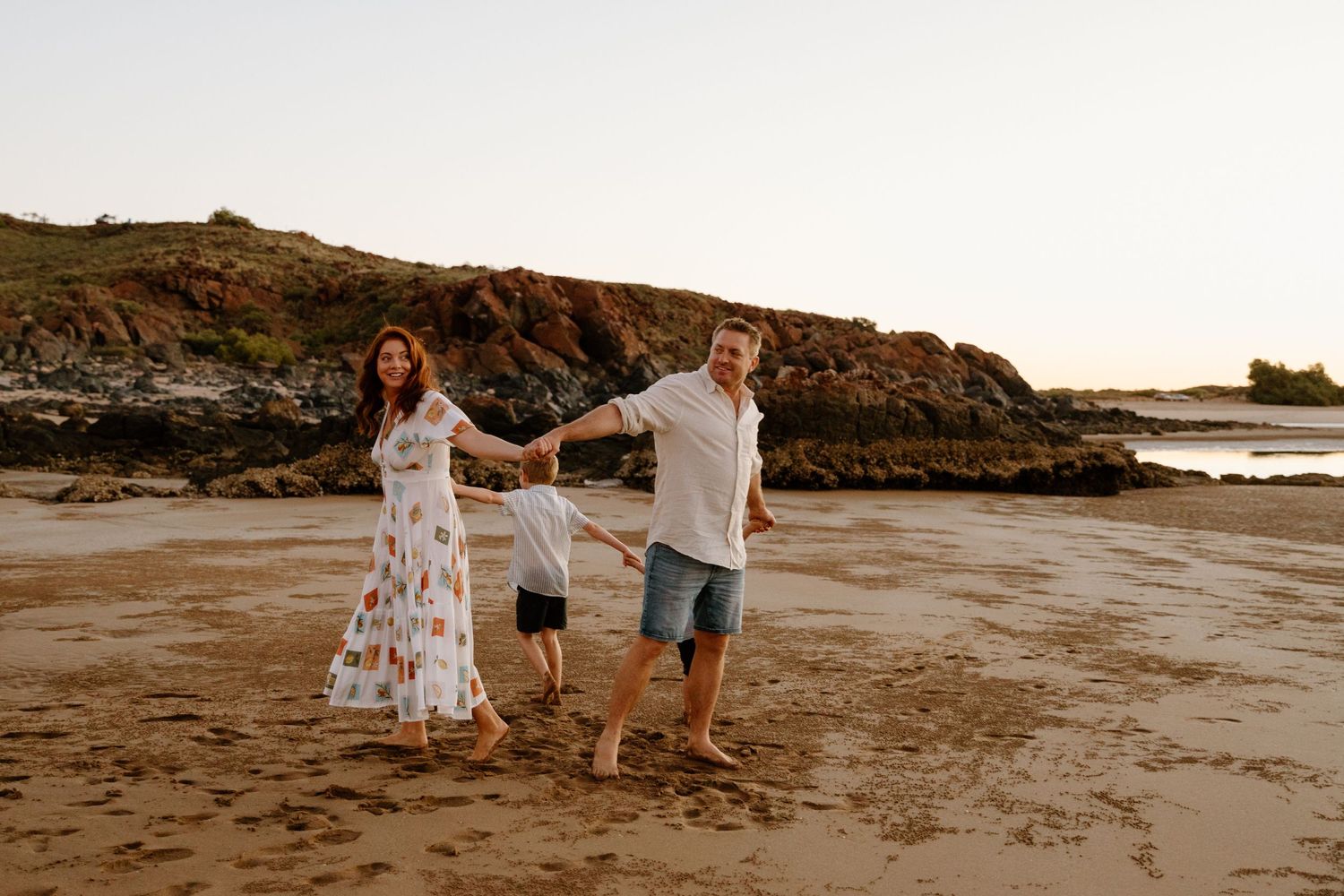 A family plays a game on the beach during a family photoshoot in Wickham, WA
