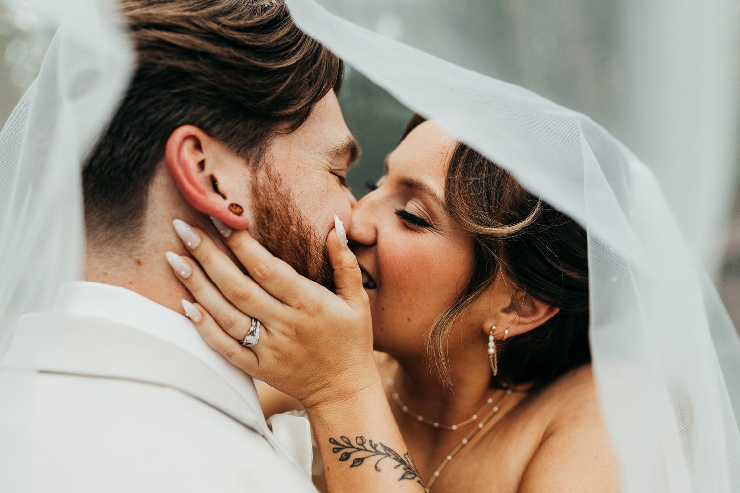 A bride and groom sharing a joyful moment during their wedding day. The couple is seen embracing, with the bride wearing a stunning white go