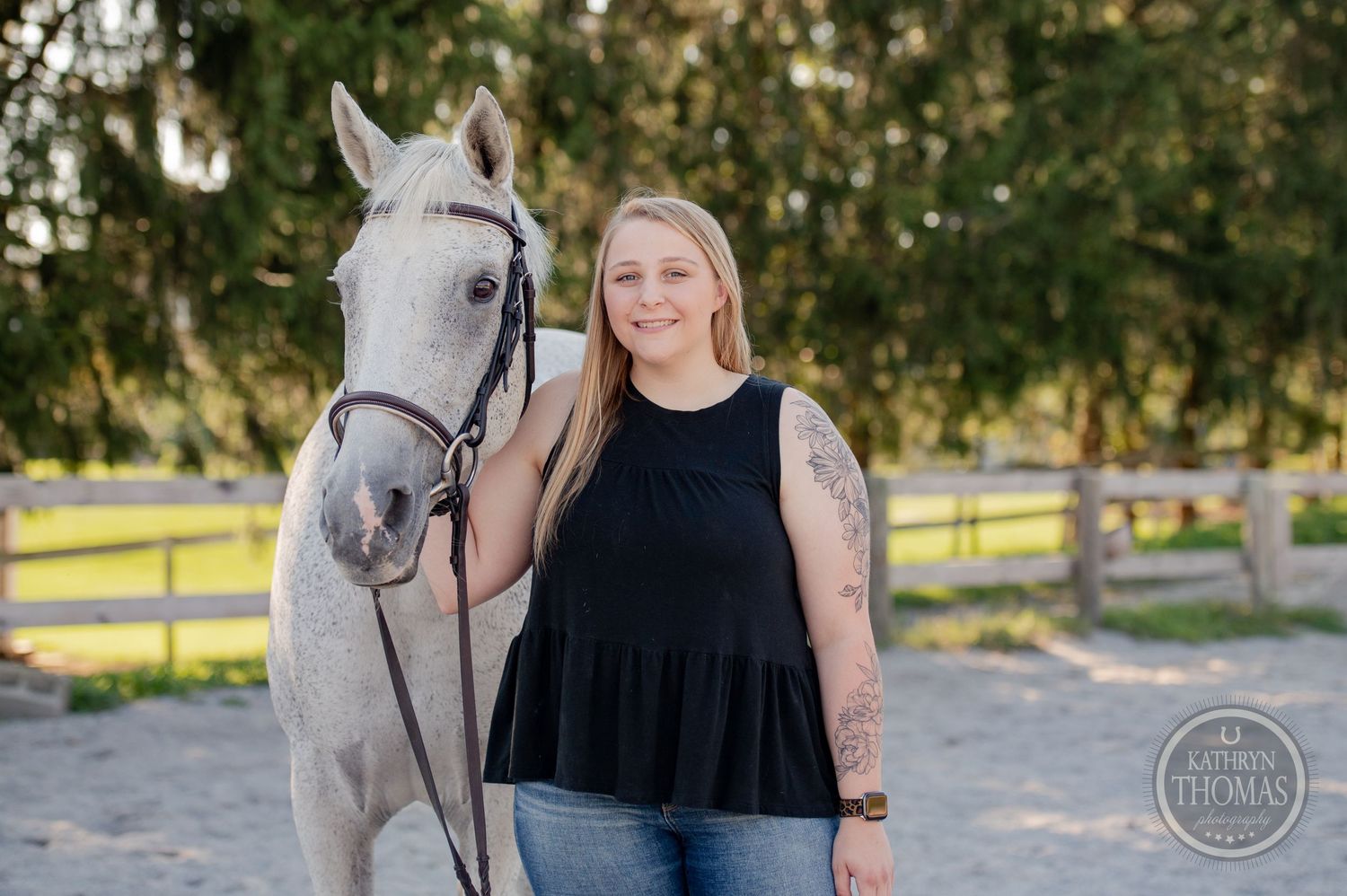 A white horse and owner share a peaceful moment in a sunny paddock.