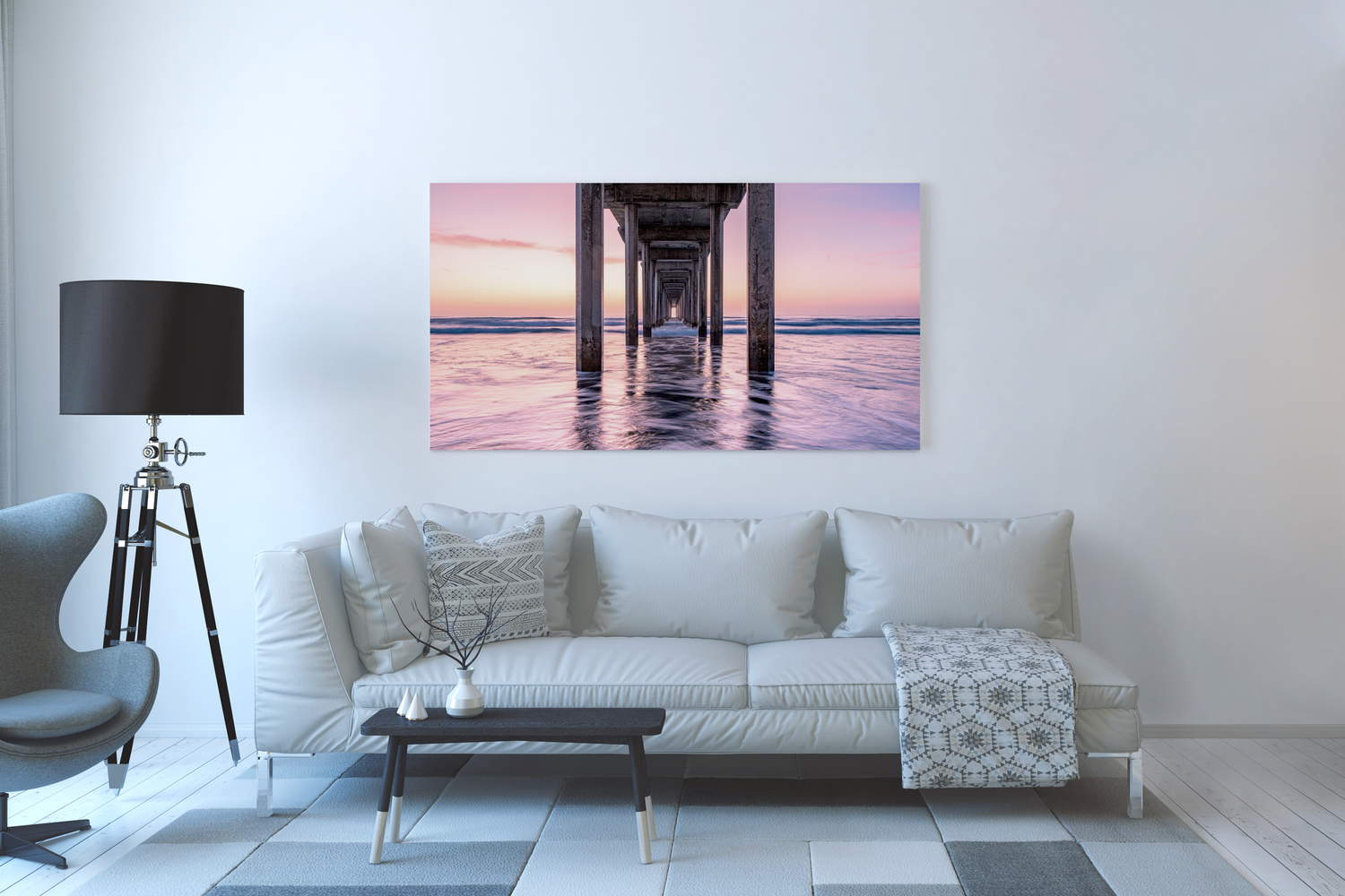 A living room with a metal print of a sunset as viewed from under a long pier