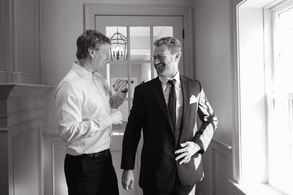 Two people share conversation in a bright interior hallway.