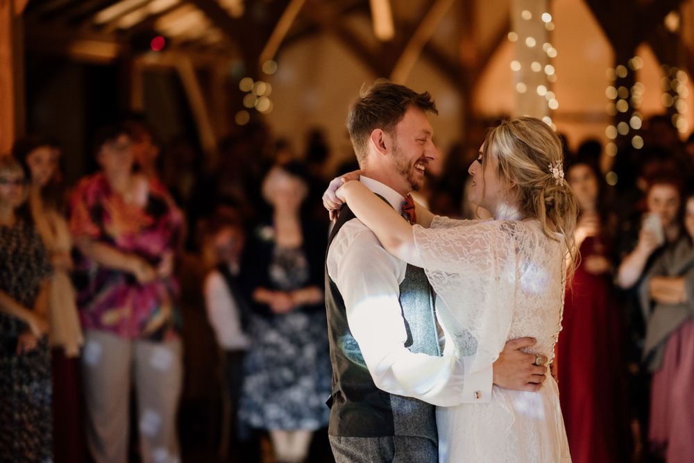 Couple shares romantic dance under twinkling lights at their wedding reception.