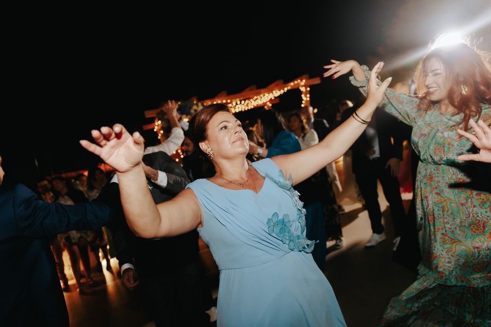 People dancing and enjoying themselves at a lively indoor party or celebration with lights and movement.