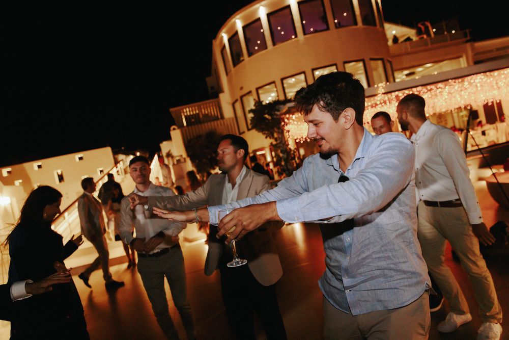 People dancing together at a festively lit outdoor venue during an evening event.