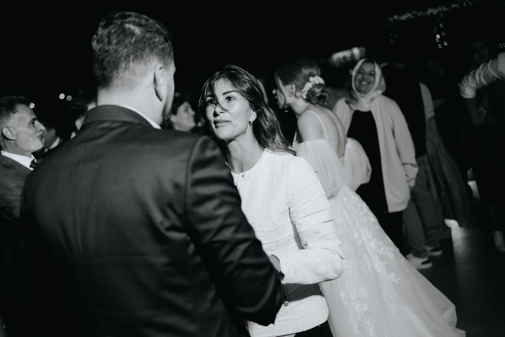 A couple shares an intimate dance moment in black and white at their wedding reception.
