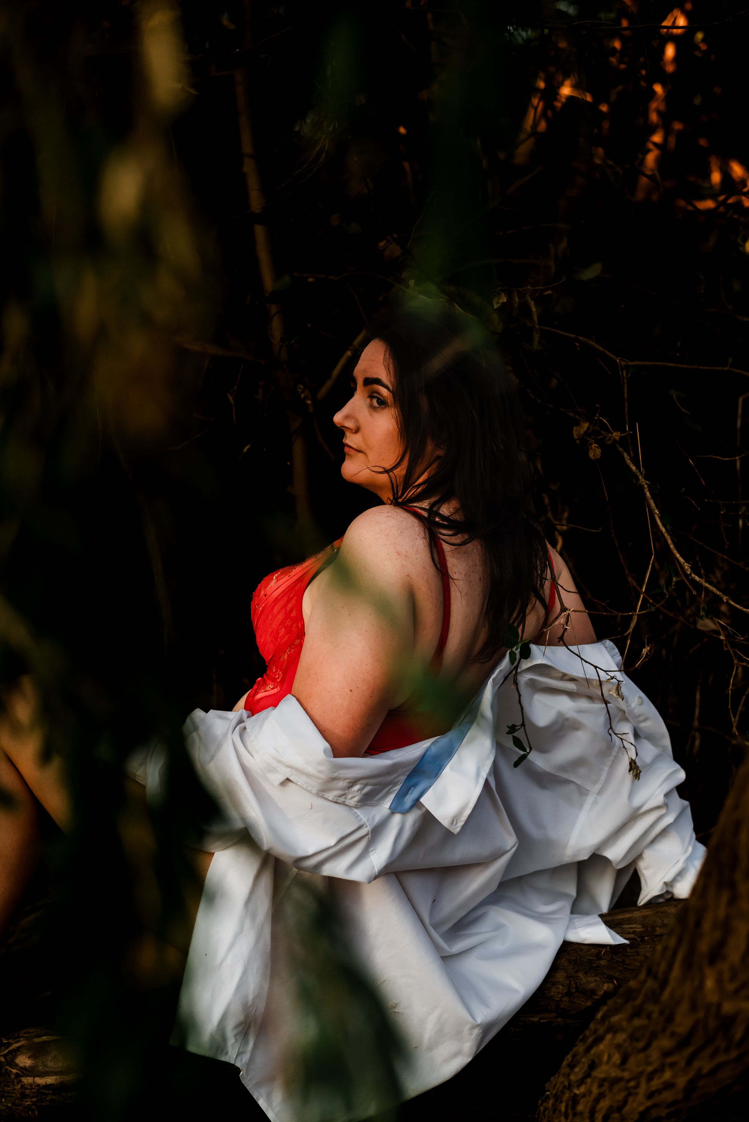 Artistic portrait in dramatic lighting with white and red garments.