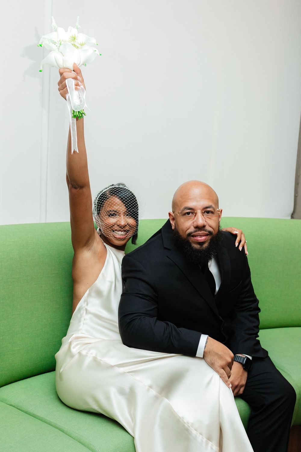 A couple in formal attire poses together on a bright green couch in a series of candid shots.