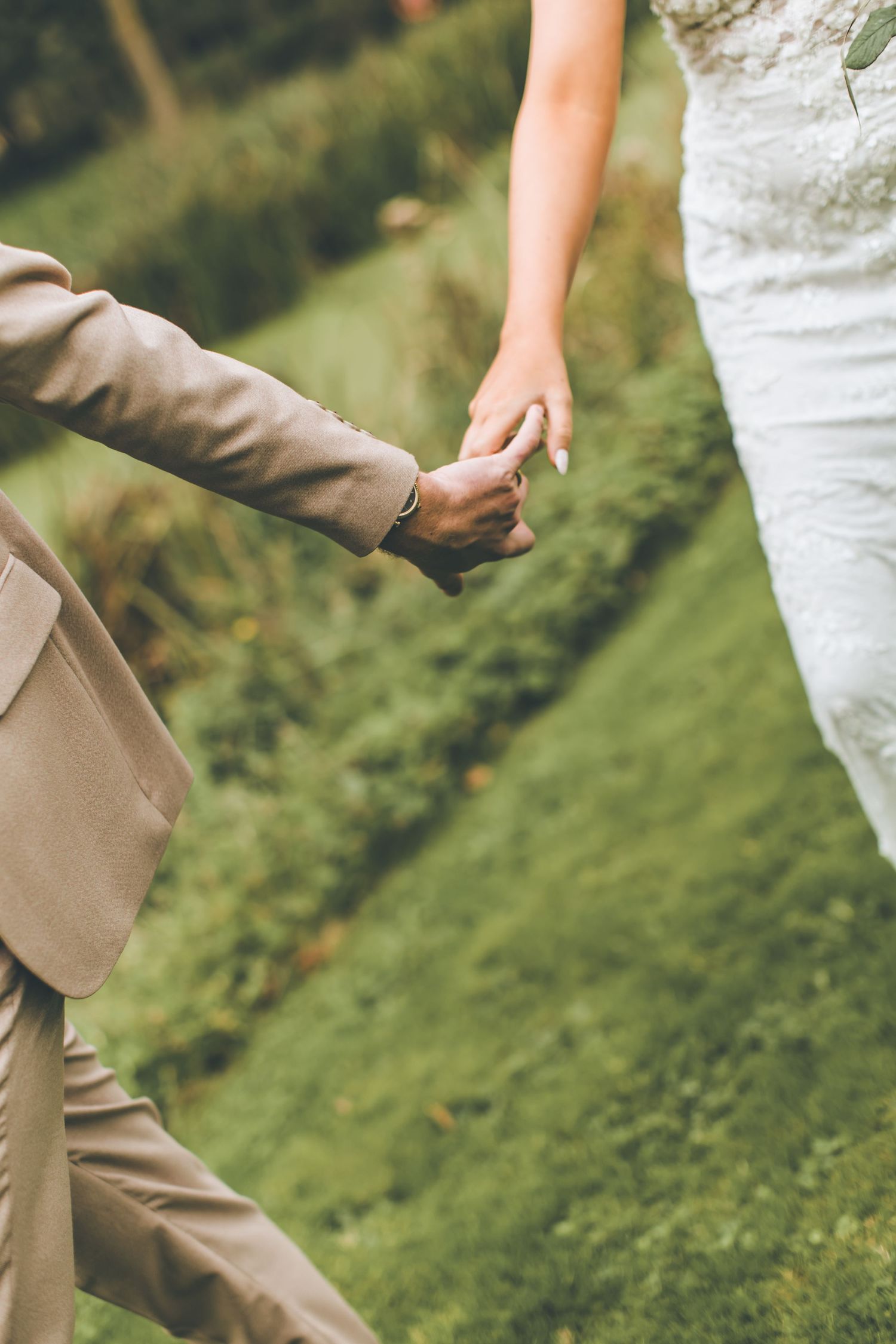 Wedding ceremony setup outdoors with rustic stone walls and natural greenery in a garden setting.