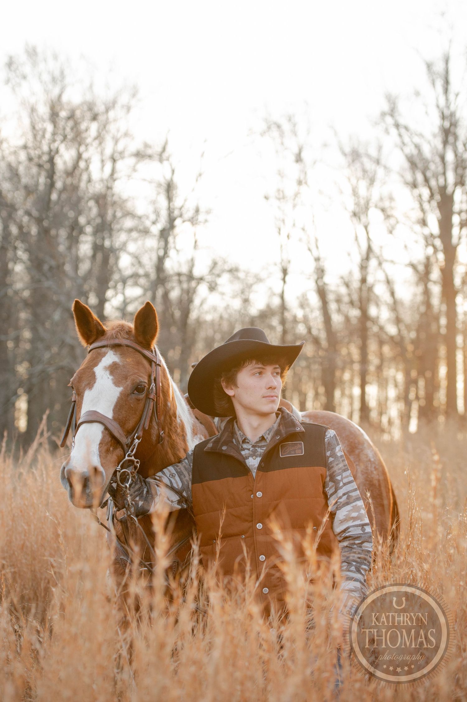 A western-style portrait of a paint horse and rider in golden autumn grass.