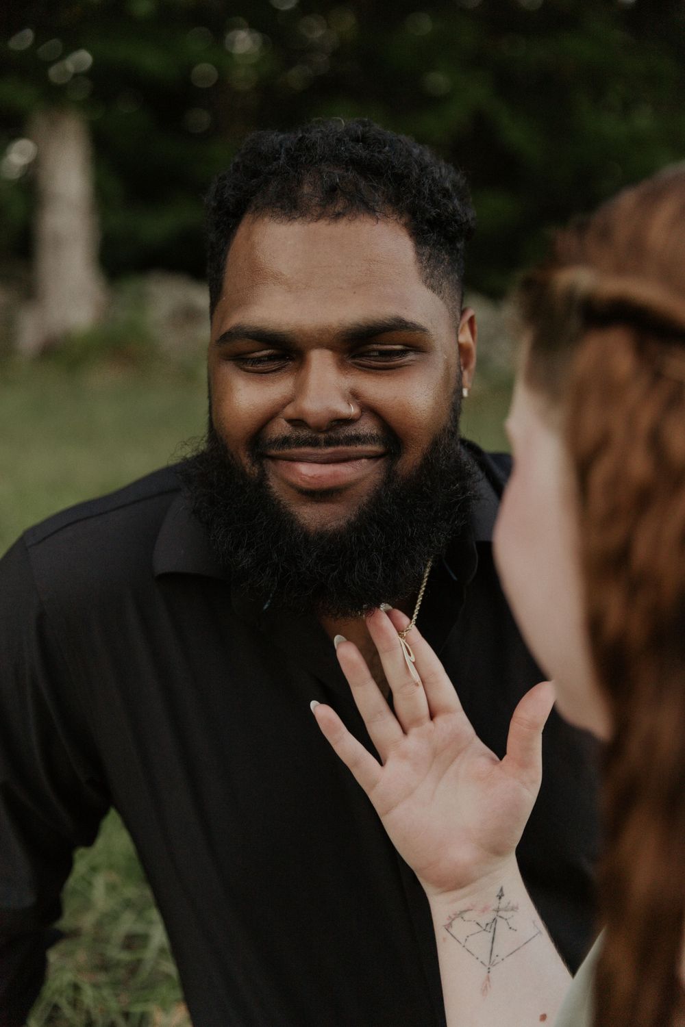 An intimate outdoor portrait capturing a warm smile and emotional reaction.