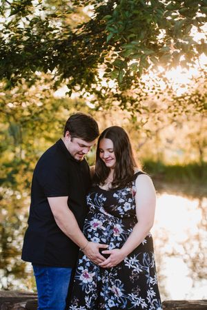 Close-up of a happy couple celebrating their pregnancy at a scenic outdoor venue.
