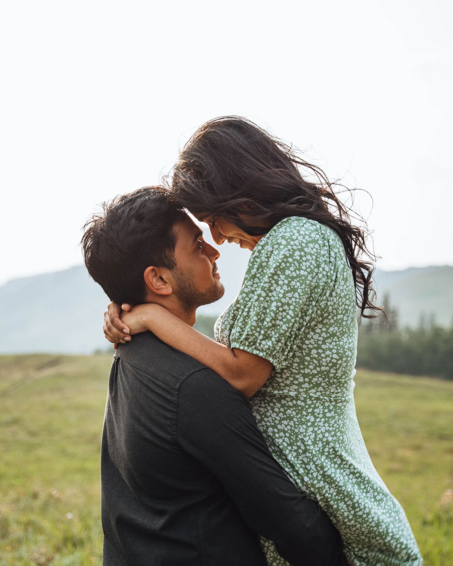Couple embracing in a field. Banff engagement photography.