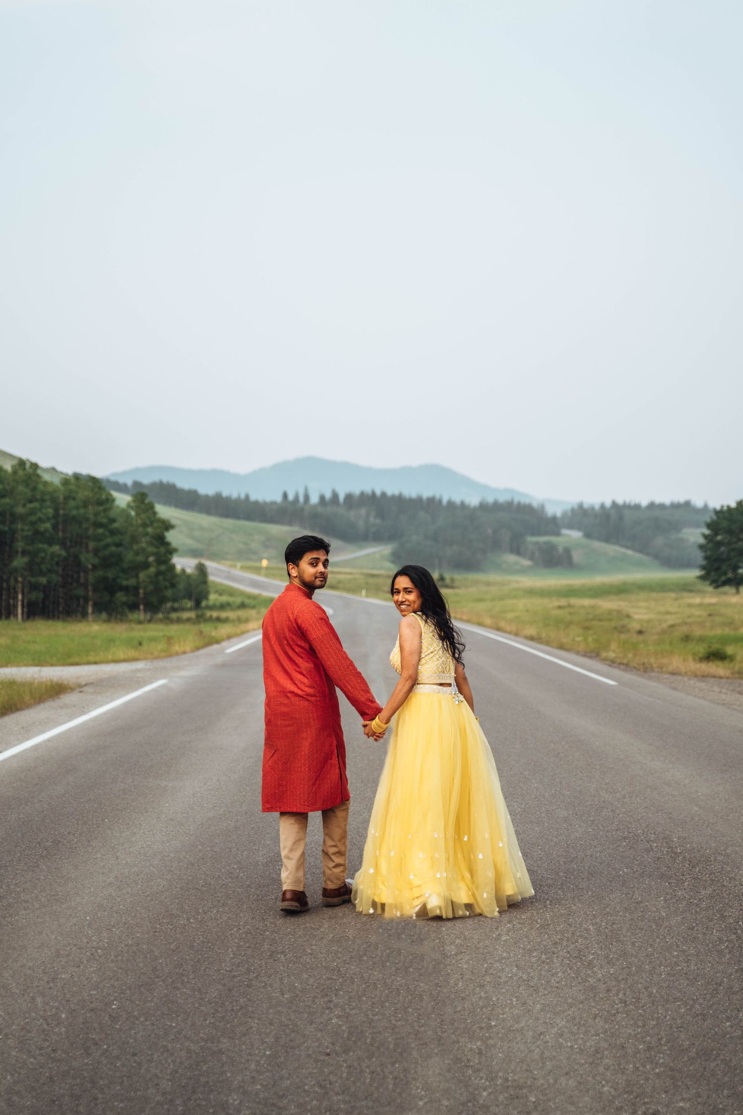 Couple walking on a road with a view. Banff engagement.
