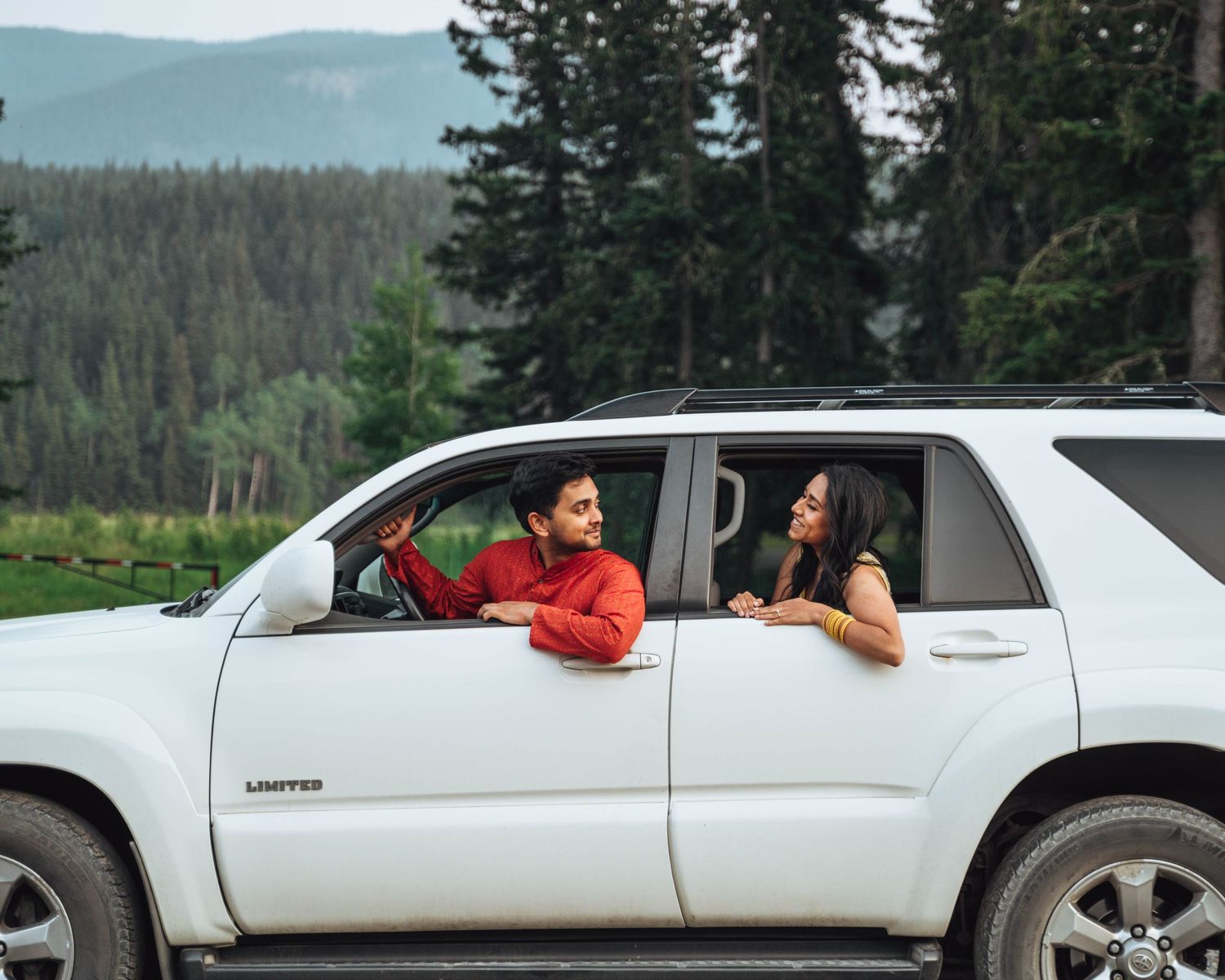 Couple in a car on a road trip. Banff engagement.