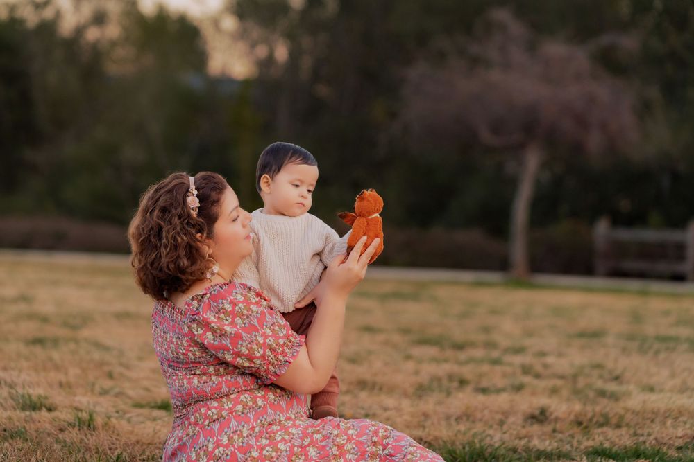 Outdoor sunset portrait with orange toy in grassy field.
