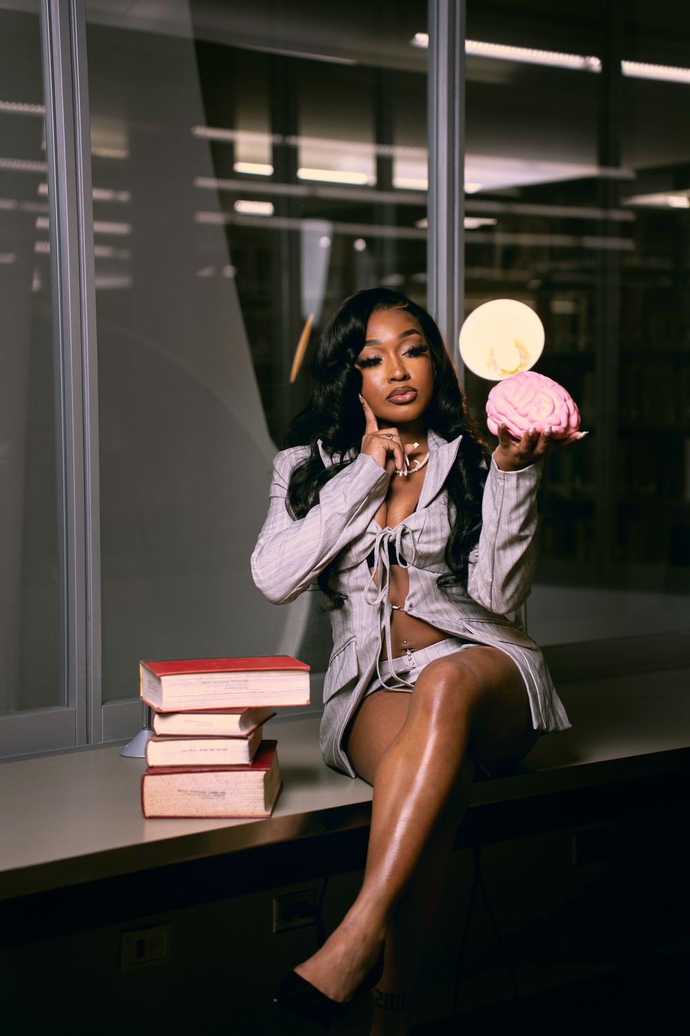 A woman in a white shirt poses with books in a series of artistic indoor portraits.