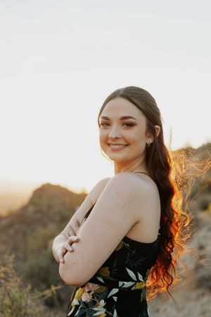 Sunset portrait photography in the desert with warm golden lighting and mountain views.