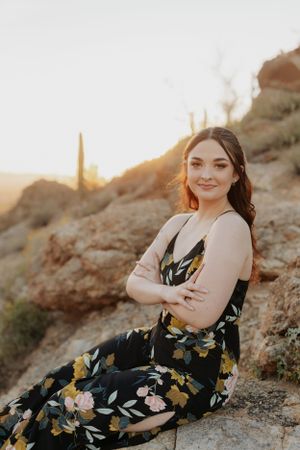 Desert photography session featuring casual poses against a mountainous backdrop at sunset.