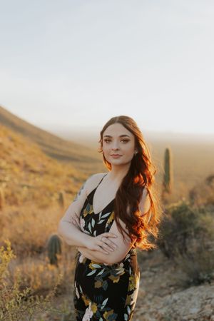 Artistic desert portrait with dramatic lighting and saguaro cacti in the background.