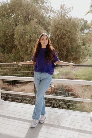 Figure strikes carefree poses on white deck with desert landscape in background.