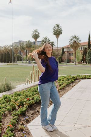 Figure in casual attire strikes dynamic poses on tiled pathway surrounded by desert landscaping.