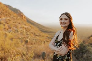 A joyful outdoor portrait session in a desert setting with mountains in the background.