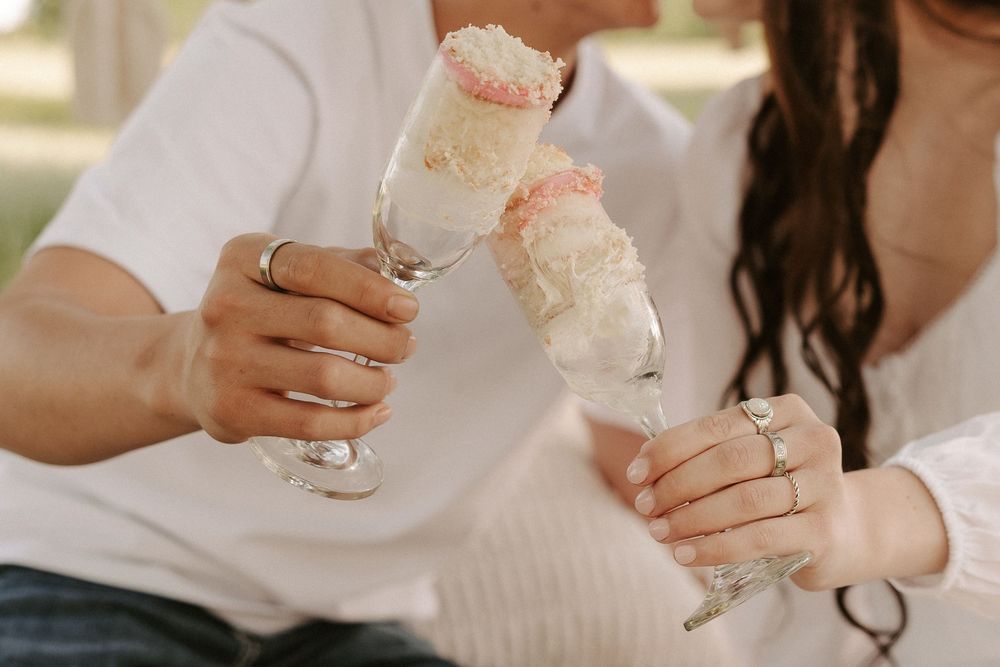 A row of wedding guests raise their champagne glasses in a celebratory toast at an elegant reception.