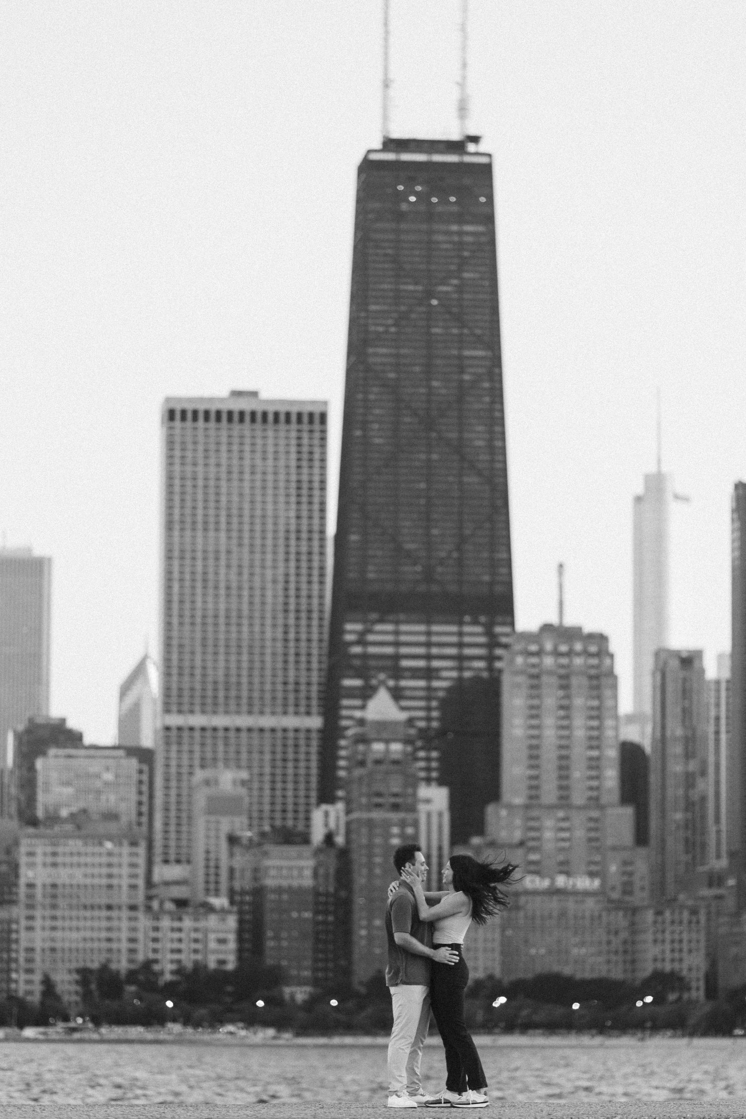 A couple dancing on a pier with the iconic Chicago skyline silhouetted in the background during sunset at North Avenue Beach