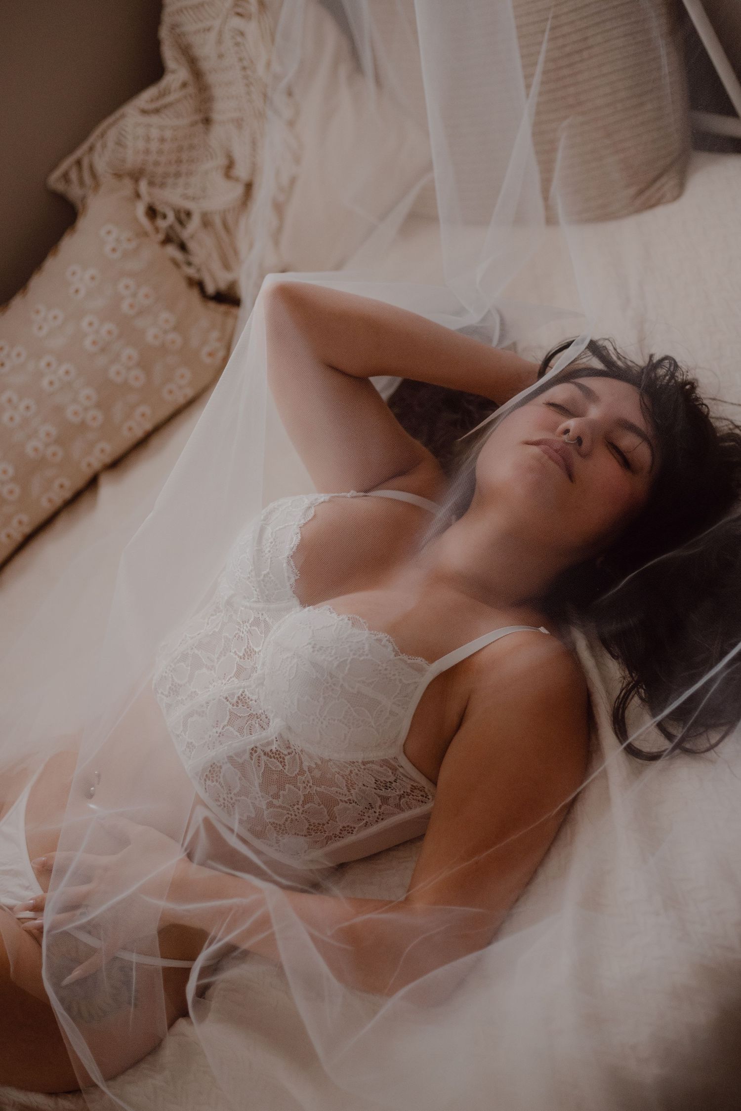 Bride under her veil during this intimate bridal boudoir session at a studio.